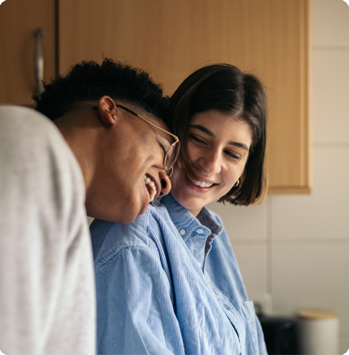 Two people in a close relationship smiling and laughing in a kitchen